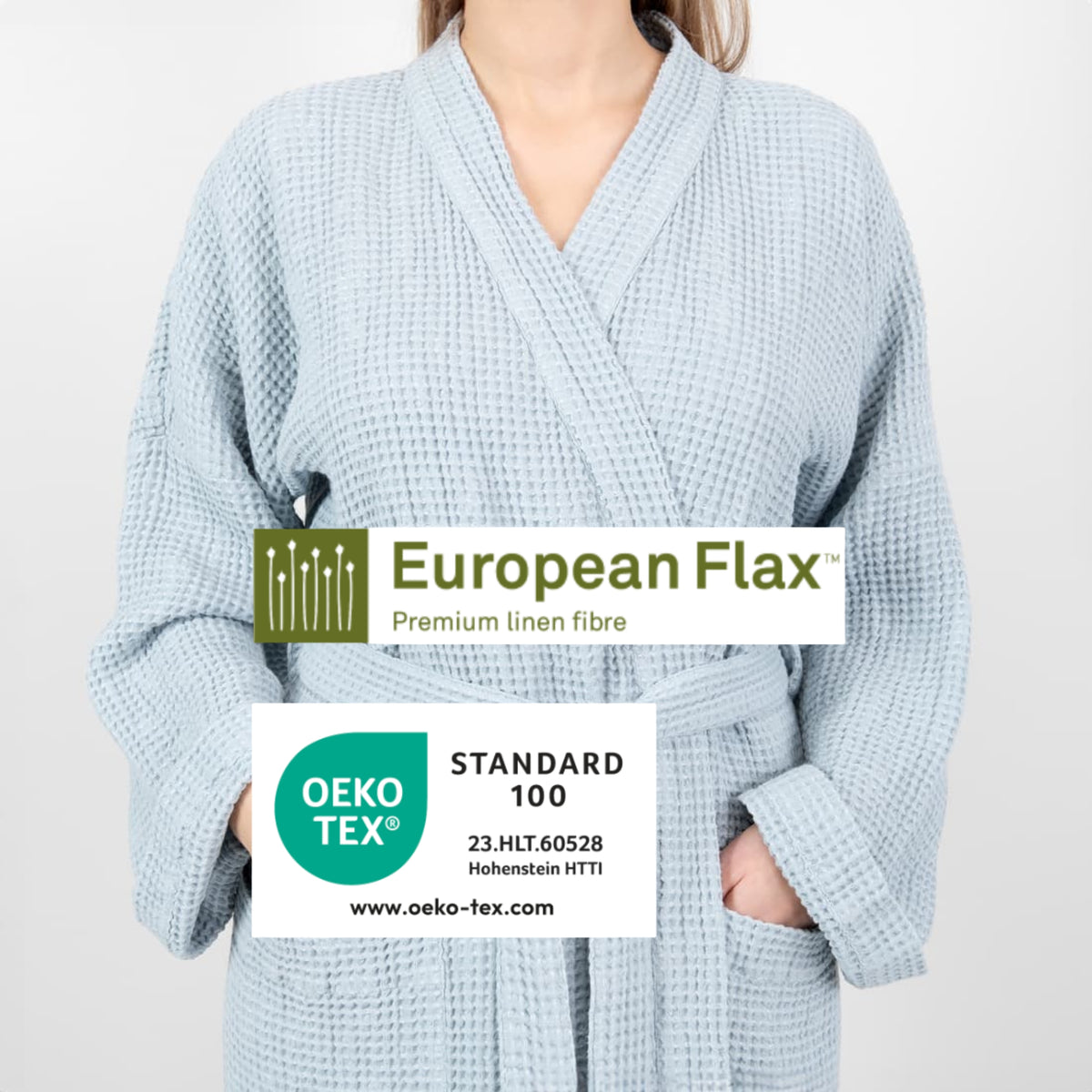 A person wearing a light blue waffle-textured bathrobe, shown from the shoulders down against a plain light background. Two certification/branding overlays are visible: a white 'European Flax Premium linen fibre' label and a white 'OEKO-TEX Standard 100' label.